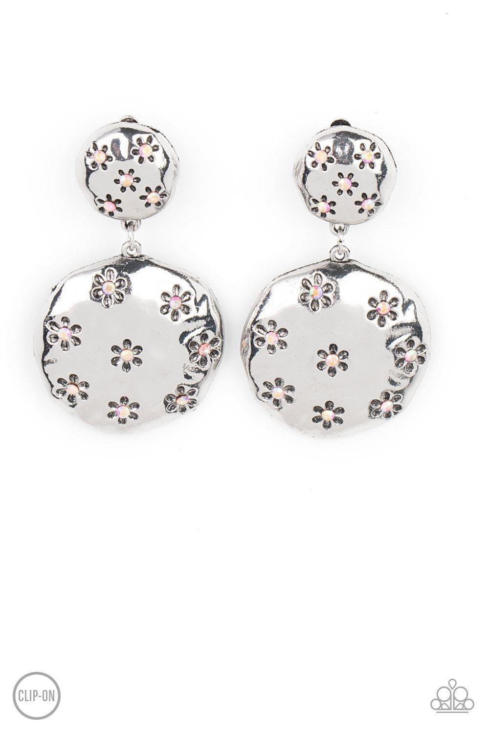 Paparazzi Accessories Industrial Fairytale - Pink *Clip-On Dotted with dainty iridescent pink rhinestone centers, an antiqued floral pattern is stamped across the fronts of two hammered silver discs that delicately connect into a rustic lure. Earring atta