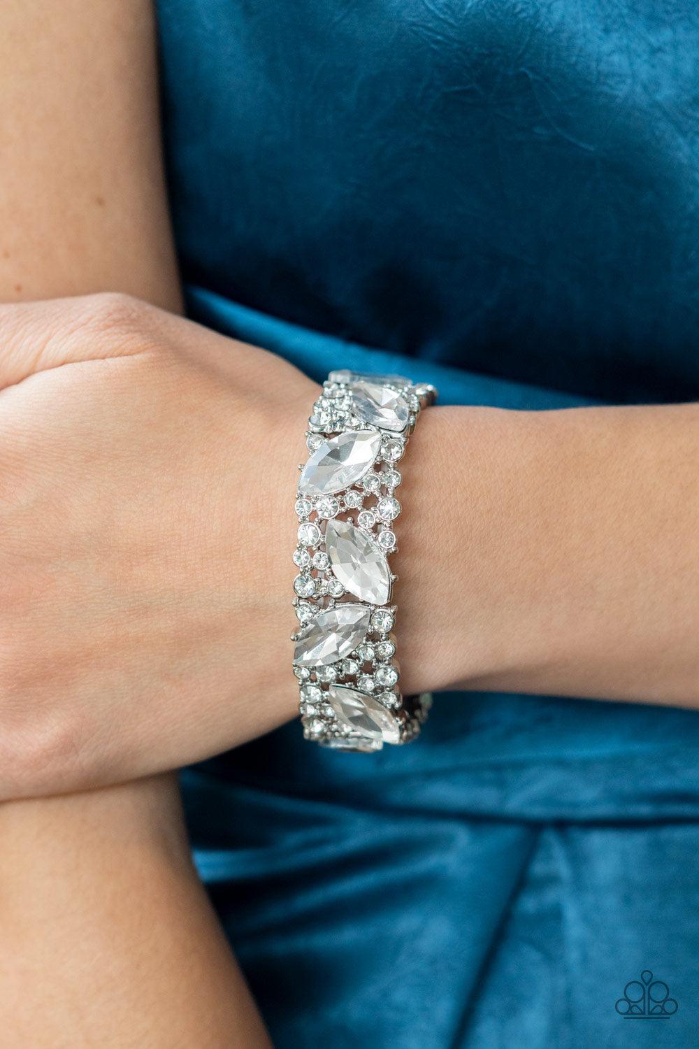 Paparazzi Accessories Full Body Chills - White Oversized marquise cut white rhinestones sparkle atop icy frames of dainty silver studs and white rhinestones that are threaded along stretchy bands around the wrist for a jaw-dropping dazzle. Sold as one ind