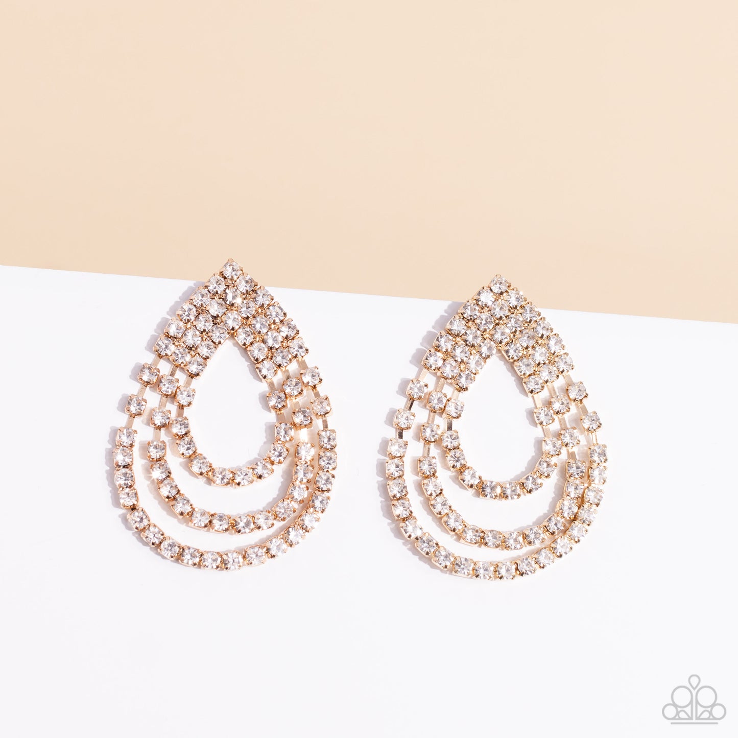 Paparazzi Accessories Take a POWER Stance - Gold Loops of glassy white rhinestones ripple out from the bottom of a stationary triangular fitting that is dotted in glittery white rhinestones, resulting in a timeless teardrop chandelier. Earring attaches to