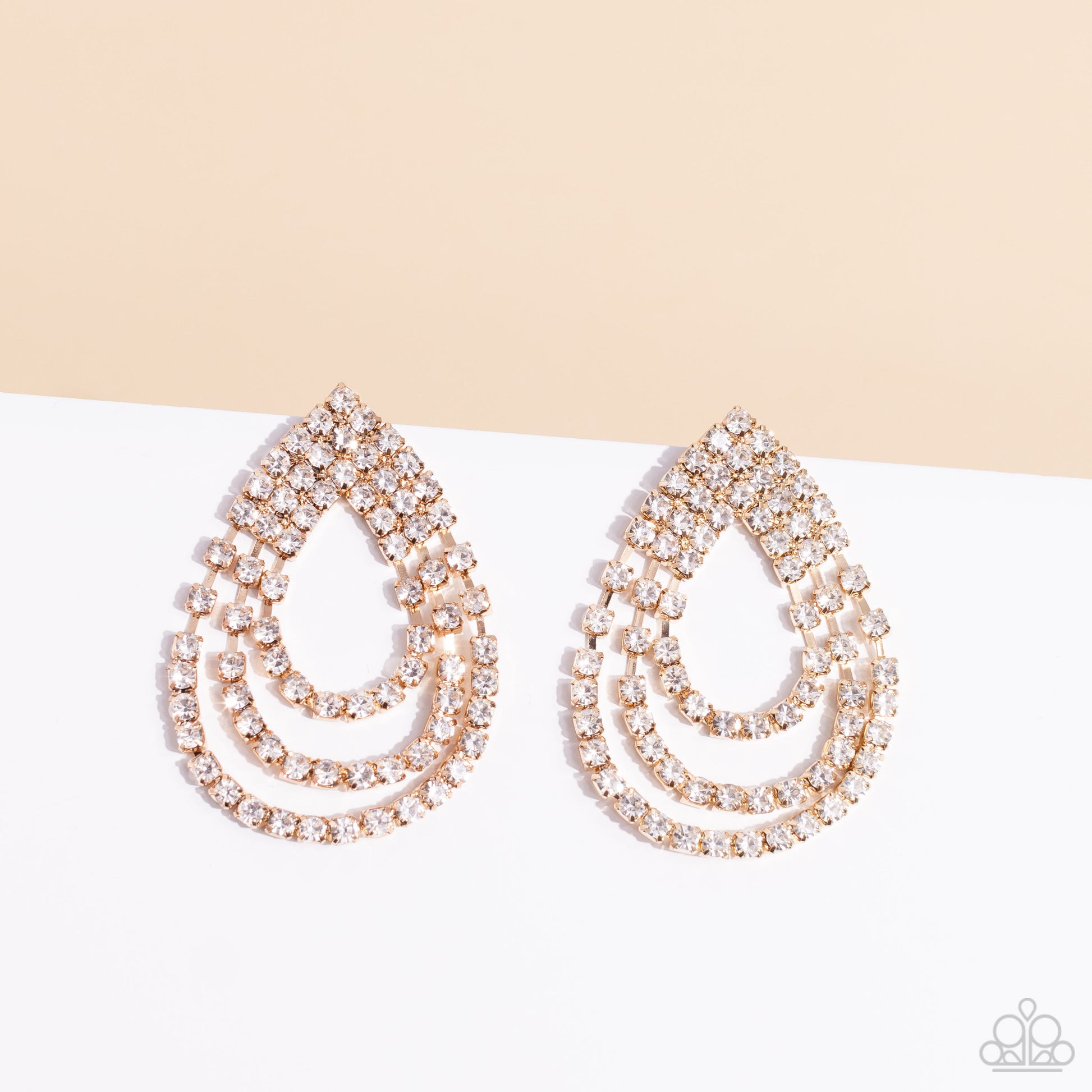 Paparazzi Accessories Take a POWER Stance - Gold Loops of glassy white rhinestones ripple out from the bottom of a stationary triangular fitting that is dotted in glittery white rhinestones, resulting in a timeless teardrop chandelier. Earring attaches to
