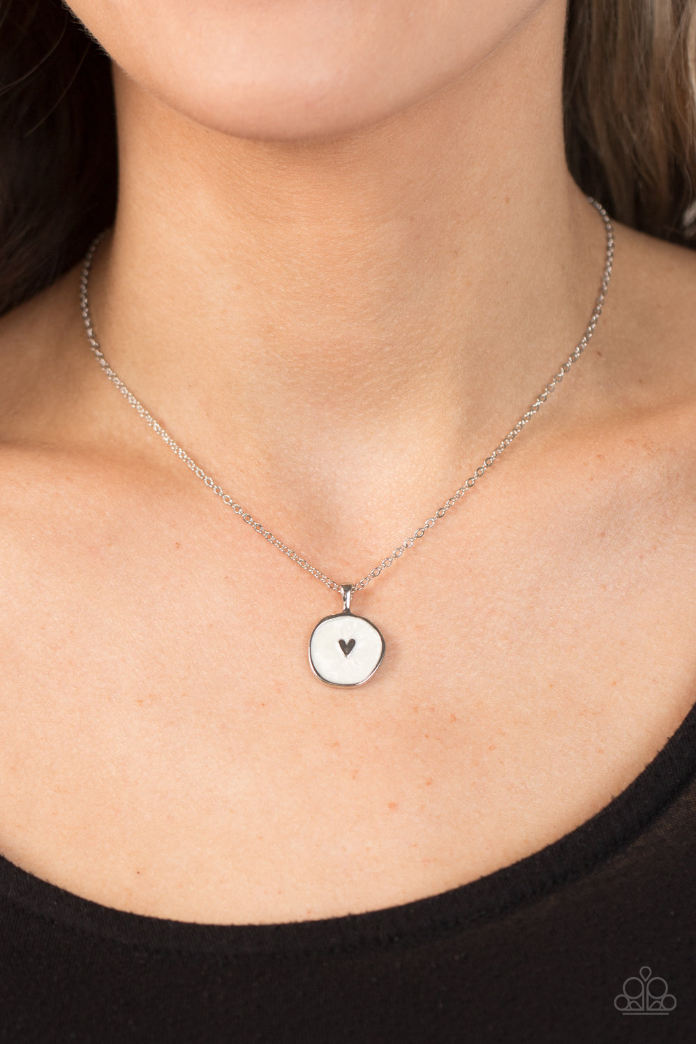 Paparazzi Accessories Do What You Love - White Painted in a shimmery white lacquer finish, an asymmetrical silver disc is dotted in a dainty silver heart accent as it swings from the bottom of a dainty silver chain below the collar for a charming finish.