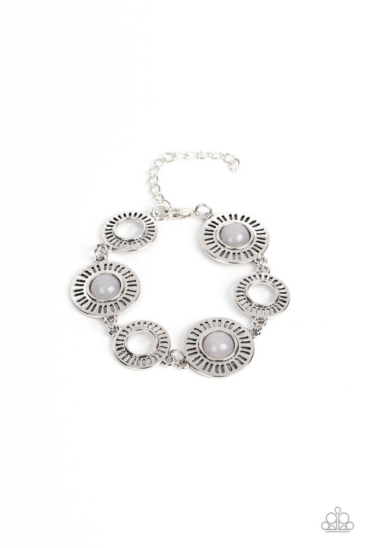 Paparazzi Accessories Coastal Charmer - Silver Airy silver frames radiate around open centers while larger silver frames feature linear cutouts with milky bead centers in the Pantone® of Northern Droplet. The cheerful designs link together around the wris
