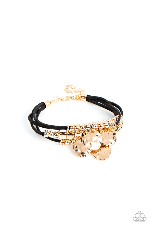 Paparazzi Accessories Token Trek - Gold Asymmetrical, hammered gold discs swing from layers of black suede that are adorned with gold discs, beads, and cubes, resulting in noisemaking shimmer around the wrist. Features an adjustable clasp closure. Sold as
