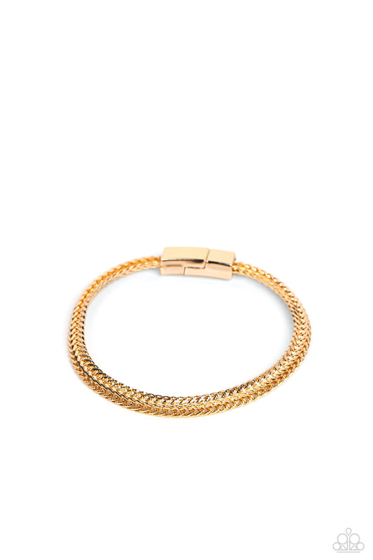 Paparazzi Accessories Cable Train - Gold Intricate gold chains interlock into an edgy centerpiece around the wrist, resulting in a gritty statement piece. Features a magnetic closure. Sold as one individual bracelet. Jewelry