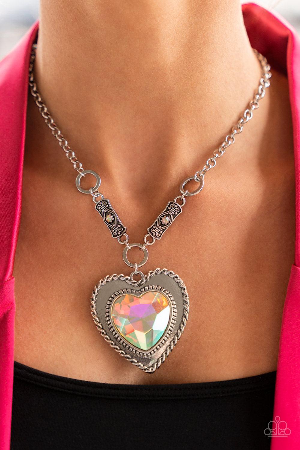 Paparazzi Accessories Heart Full of Fabulous - Multi Bordered in spun silver ribbons, an oversized iridescent heart gem is pressed into a silver heart frame below the collar. The flirtatious pendant attaches to silver rings and decorative silver frames do