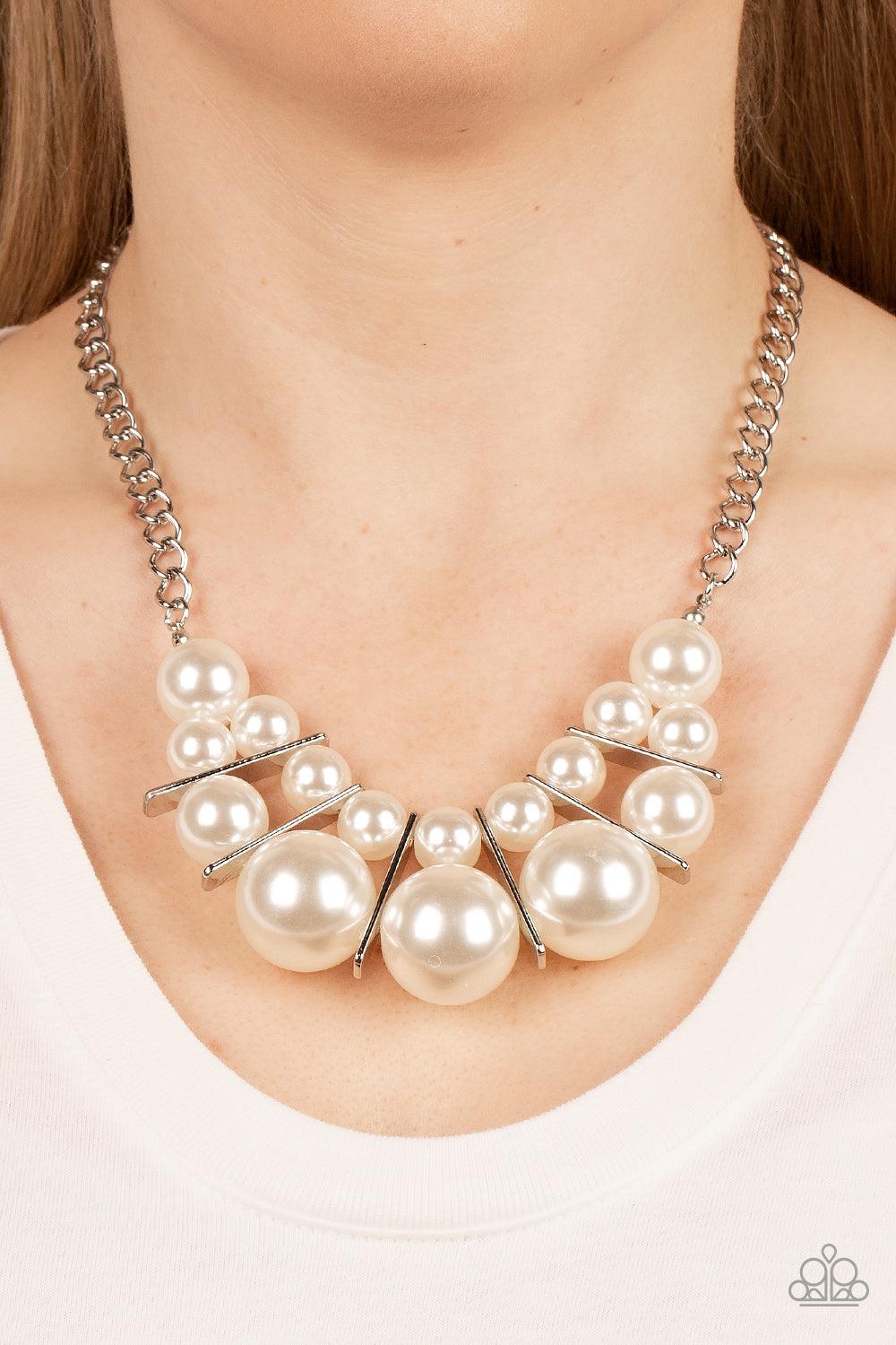 Paparazzi Accessories Challenge Accepted - White Separated by rectangular silver frames, bubbly rows of classic and oversized white pearls are threaded along invisible wires at the bottom of a chunky silver chain for an effervescent explosion below the co