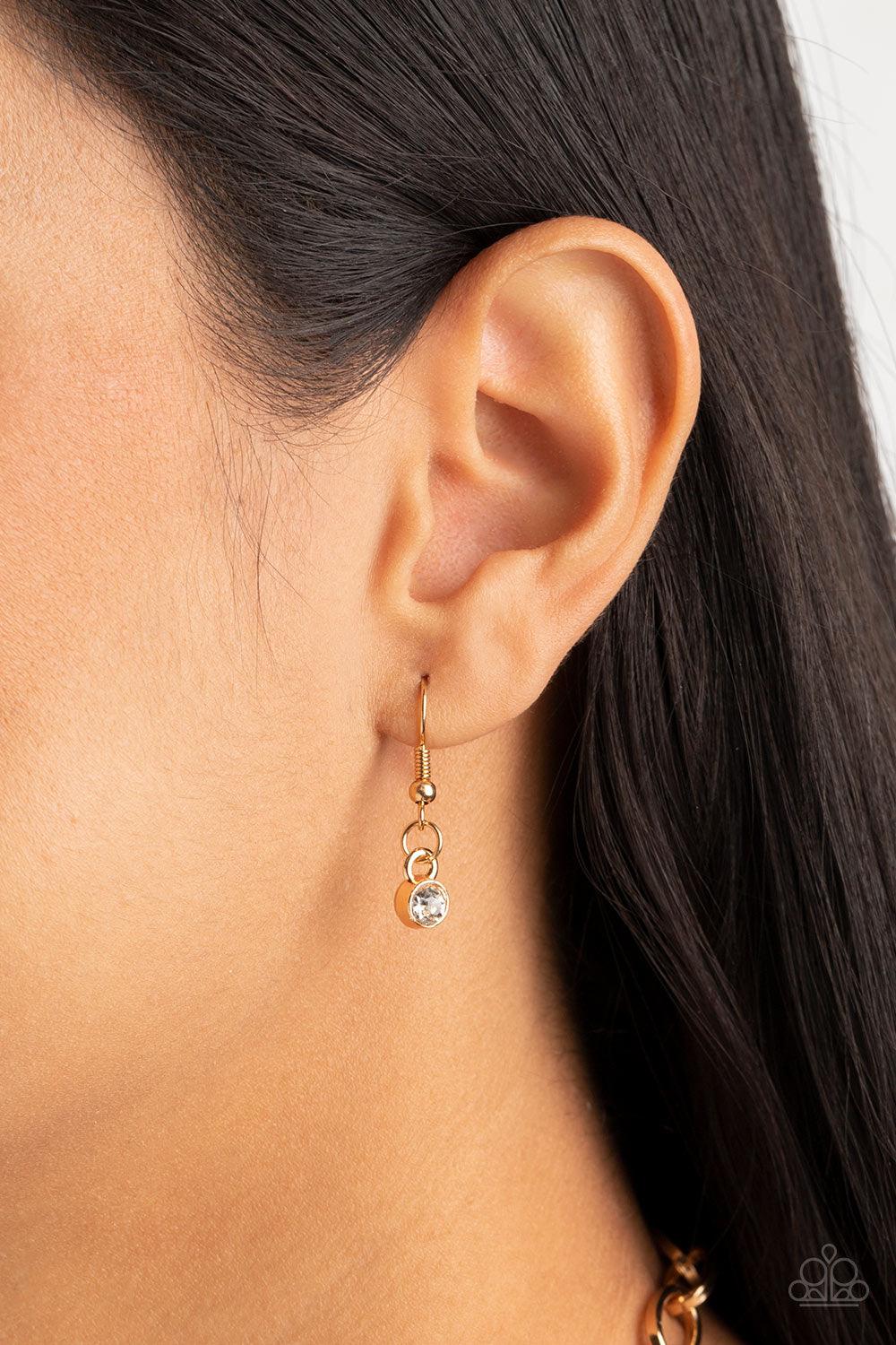 Paparazzi Accessories Limelight Luxury - Gold Set in gold pronged fittings, five dramatically oversized white rhinestones connect across the collar and attach to an oversized gold chain creating a stunning spot-light loving statement piece. Features an ad