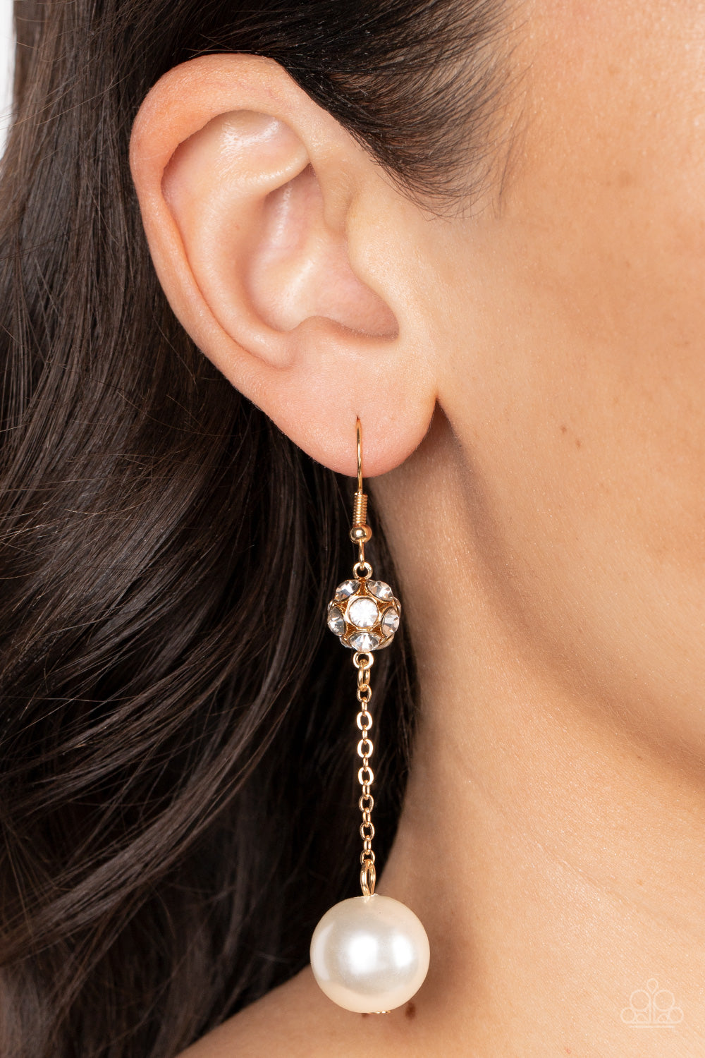 Paparazzi Accessories Nautical Nostalgia - Gold An oversized white pearl swings from the bottom of a dainty gold chain that is suspended from a white rhinestone encrusted gold bead, resulting in a timeless twist. Earring attaches to a standard fishhook fi
