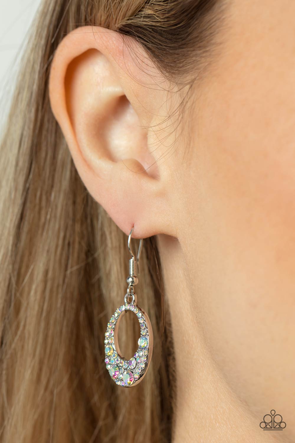 Paparazzi Accessories Showroom Sizzle - Multi A smattering of mismatched iridescent rhinestones encrusted the front of an oval silver frame, coalescing into a stellar sparkle. Earring attaches to a standard fishhook fitting. Sold as one pair of earrings.