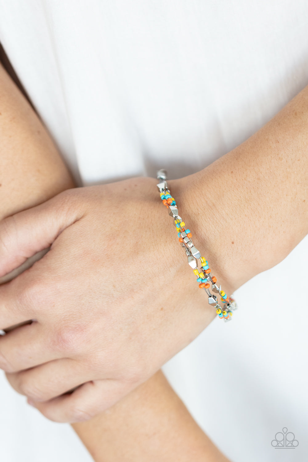Paparazzi Accessories Elite Explorer - Multi A dainty collection of faceted silver beads, multi-colored seed beads, and silver cubes are threaded along multiple strands of silver wire around the wrist, creating clustered layers. Features an adjustable cla