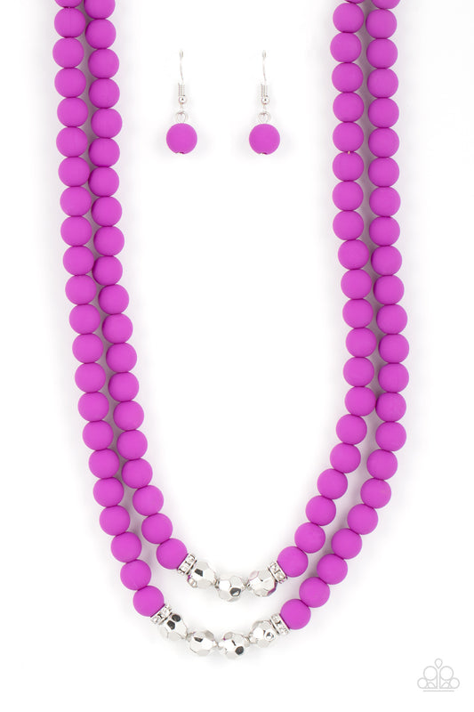 Paparazzi Accessories Summer Splash - Purple Threaded along invisible wires, matte-finished Dahlia beads give way to center sections of white rhinestone encrusted rings and faceted silver beads. The vivacious display layers below the collar, creating a su