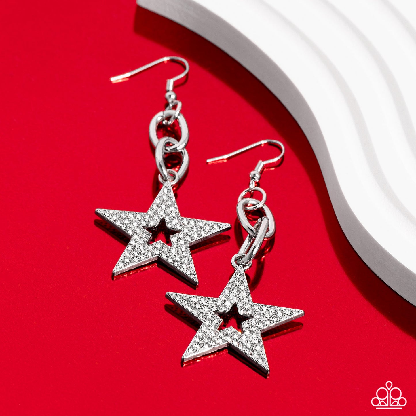 Paparazzi Accessories Cosmic Celebrity - White Glassy white rhinestones scatter across the front of a silver star at the bottom of a chunky silver chain, resulting in a stellar lure. Earring attaches to a standard fishhook fitting. Sold as one pair of ear