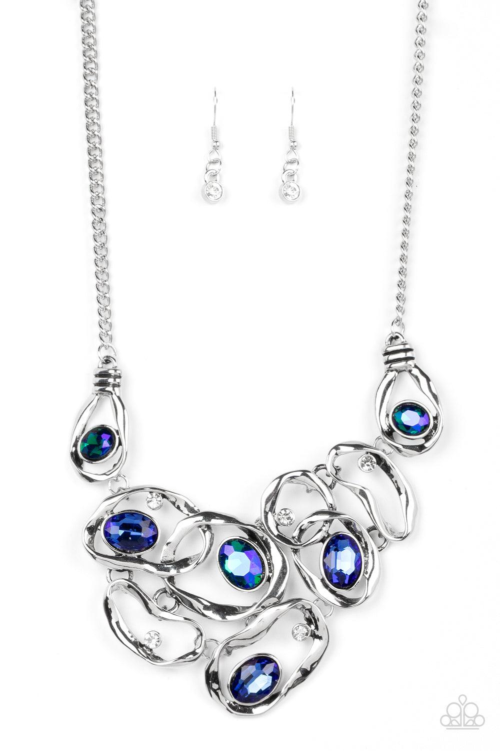 Paparazzi Accessories Warp Speed - Blue Warped silver frames asymmetrically curl around dainty white rhinestones and blue and iridescent gem accents, interlocking into a contemporary statement piece below the collar. Features an adjustable clasp closure.