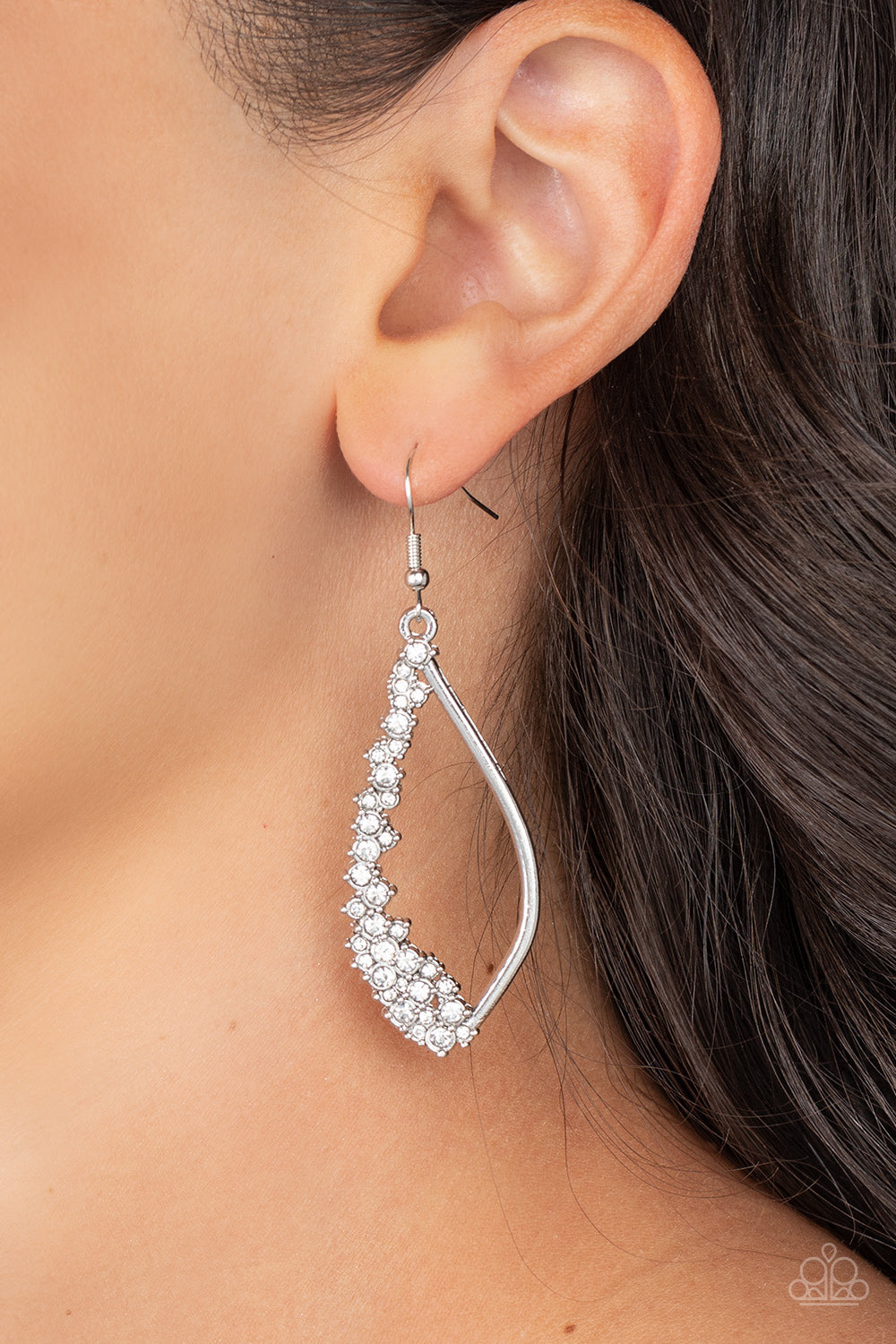 Paparazzi Accessories Sparkly Side Effects - White Set in silver pronged fittings, dainty white rhinestones tumble down one side of an airy silver lure for a bubbly blast of sparkle. Earring attaches to a standard fishhook fitting. Sold as one pair of ear