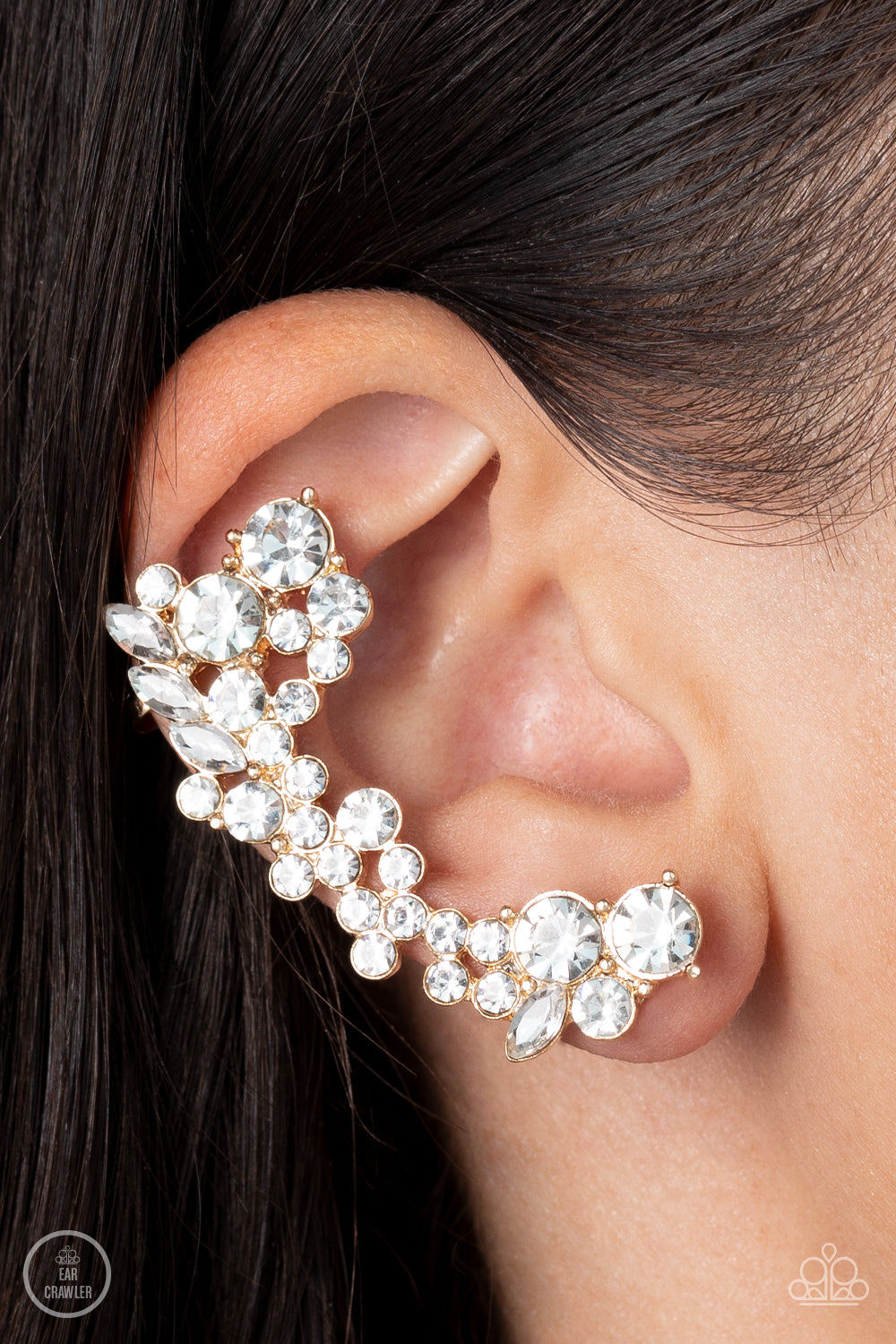 Paparazzi Accessories Astronomical Allure - Gold A sparkly collision of round and marquise cut white rhinestones tumble down the ear, coalescing into an out-of-this-world sparkle. Features a clip-on fitting at the top for a secure fit. Sold as one pair of