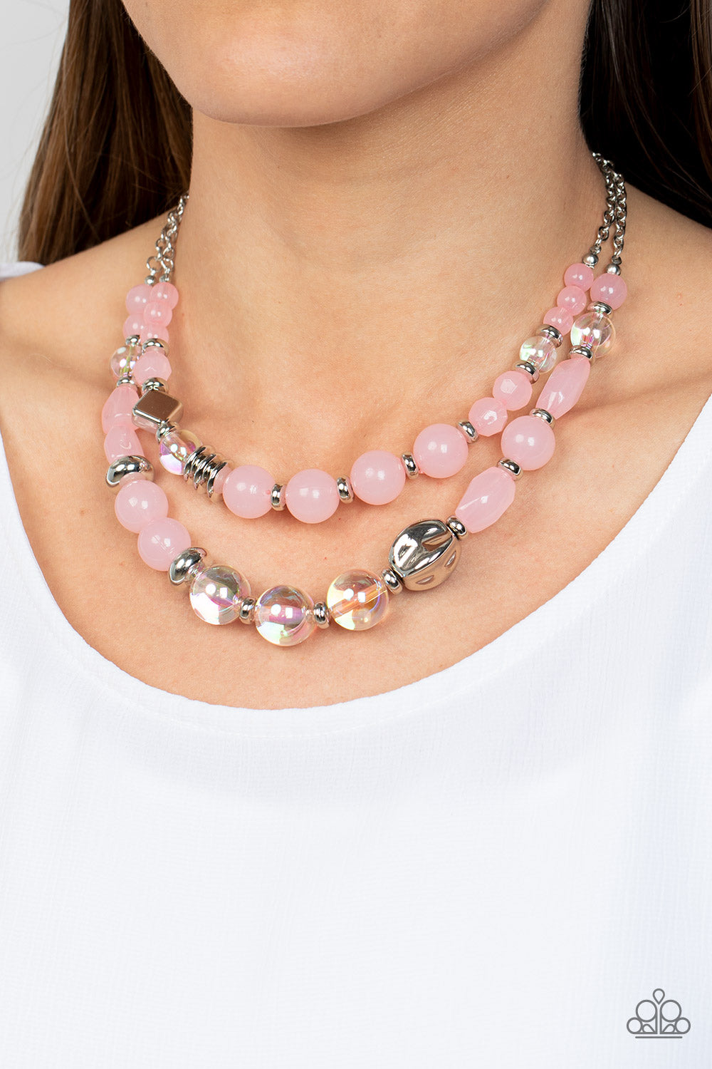 Paparazzi Accessories Mere Magic - Pink Featuring various shapes and finishes, a mismatched assortment of silver, iridescent, and opaque Gossamer Pink beads have been threaded along invisible wires below the collar, creating ethereal layers. Features an a