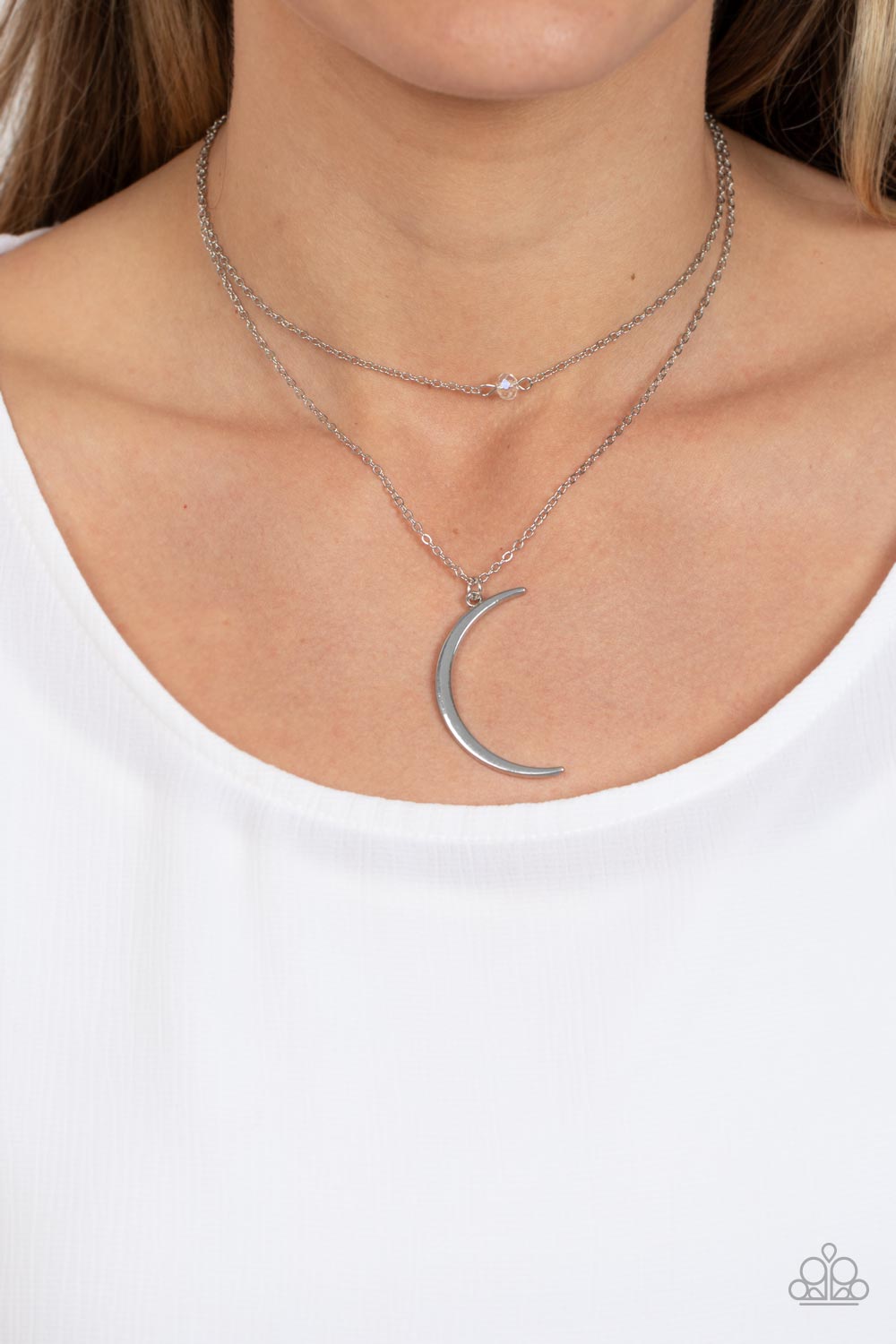 Paparazzi Accessories Modern Moonbeam - White Two dainty silver chains delicately layer below the collar. A white crystal-like bead sparkles at the center of the uppermost chain while a silver half moon pendant swings from the bottom of the display for a