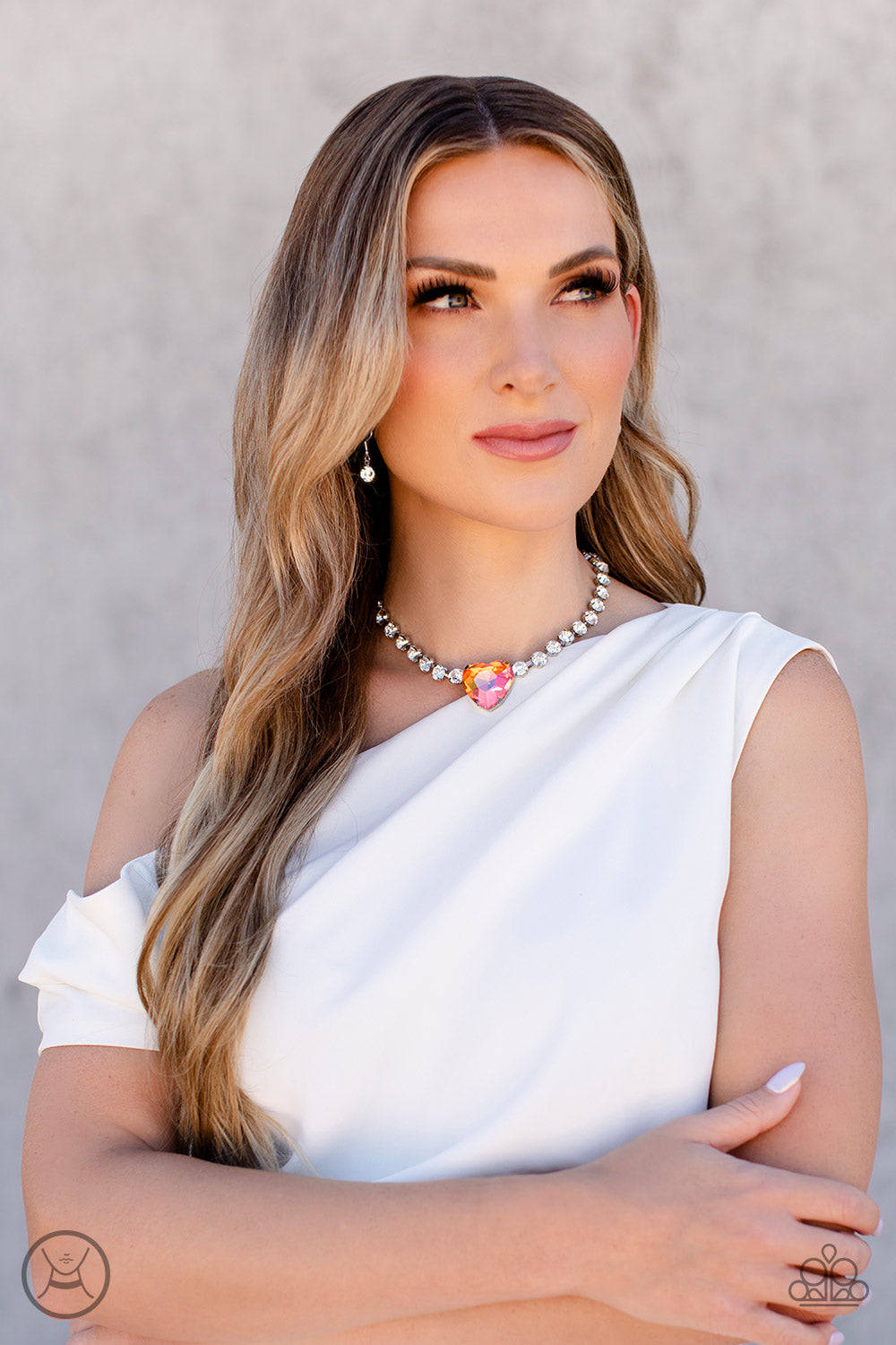 Paparazzi Accessories Heart in My Throat - Orange A dramatically oversized heart-shaped gem with a reflective, iridescent orange finish glitters at the center of a blinding row of glassy white rhinestones, resulting in a flirtatious sparkle around the nec