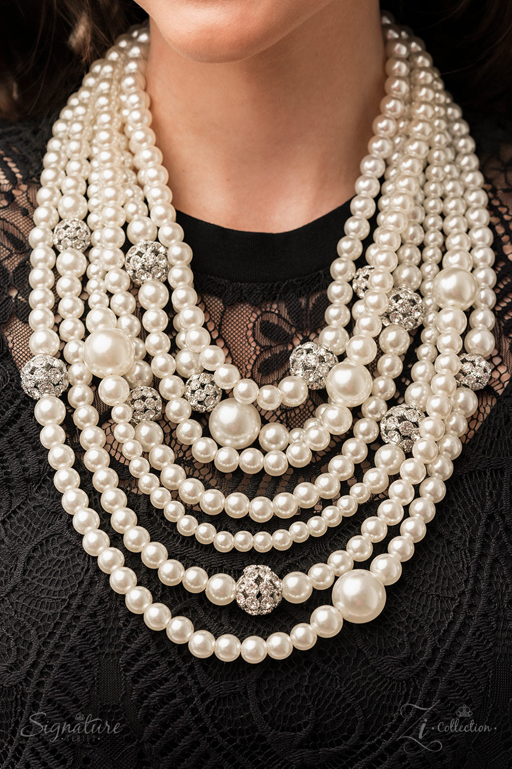 Paparazzi Accessories The Courtney Strand after strand of lustrous white pearls layer down the chest, creating timeless tiers. Airy silver spheres, adorned in sparkling white rhinestones, are effortlessly sprinkled among the sea of pearls, infusing the de