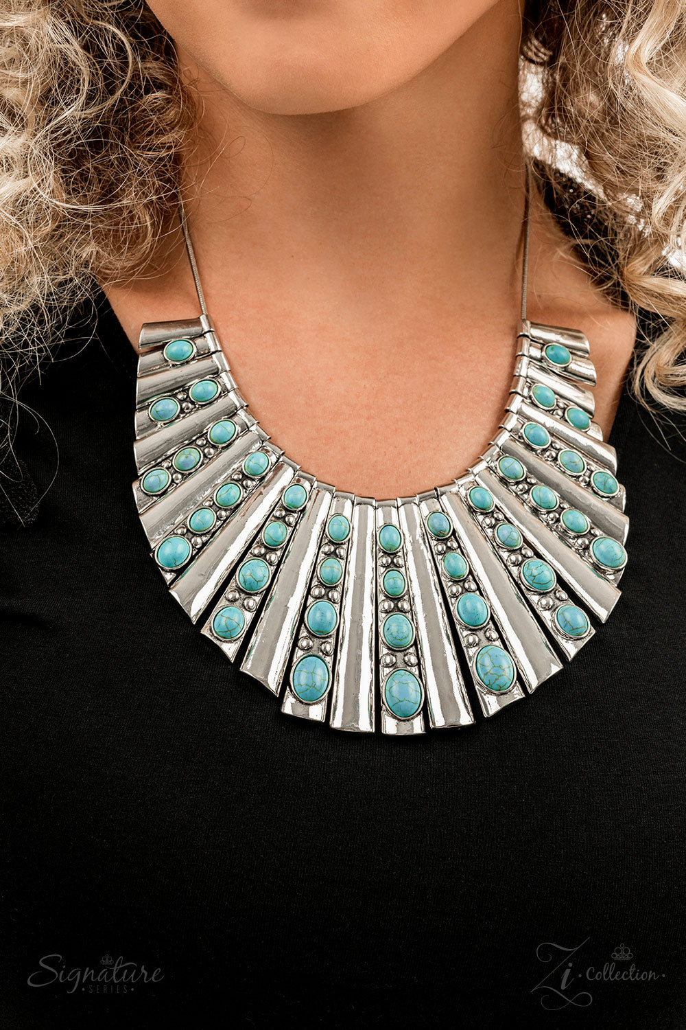 Paparazzi Accessories The Ebony Elongated silver plates featuring a high sheen finish fan out unapologetically along the collar, graduating in size as they lead down to the center. Oval-shaped turquoise stones, nestled in raised silver borders, adorn ever