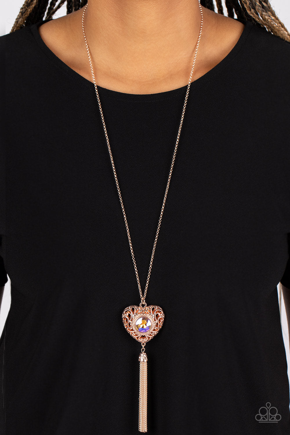 Paparazzi Accessories Prismatic Passion - Gold A magical iridescent peach gem sparkles at the center of a 3-dimensional rose gold heart. Filled with vine-like filigree, the locket inspired heart frame glides along an extended rose gold chain while a shimm