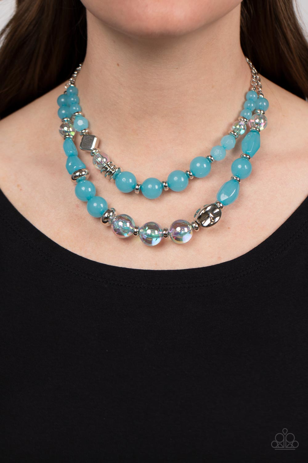 Paparazzi Accessories Mere Magic - Blue Featuring various shapes and finishes, a mismatched assortment of silver, iridescent, opaque Waterspout beads have been threaded along invisible wires below the collar, creating ethereal layers. Features an adjustab