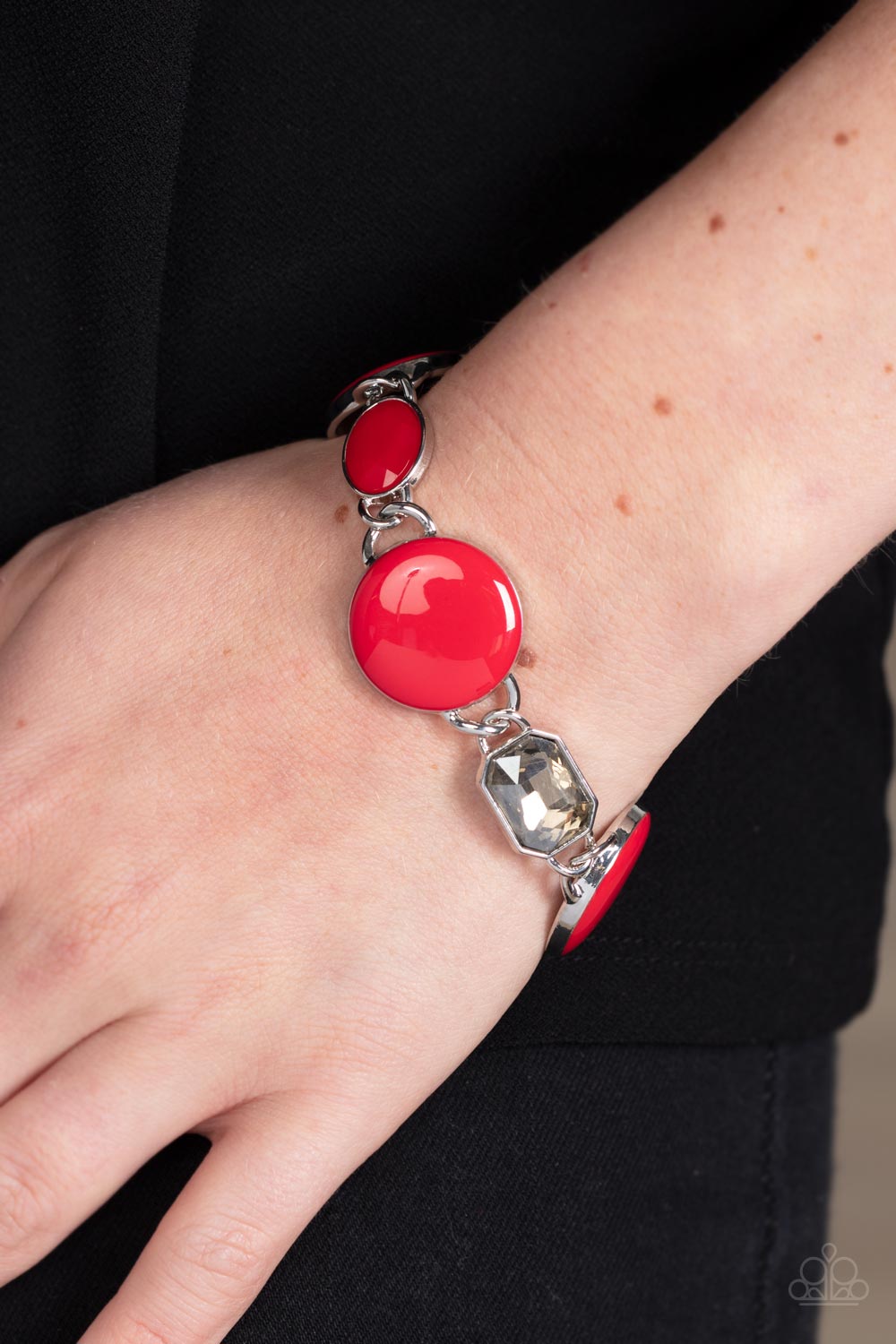 Paparazzi Accessories Dreamscape Dazzle - Red A rectangular sparkling smoky gem and a true red oval bead add elegance to a monochromatic collection of three oversized red circles. Set in silver frames, the whimsical collection attaches to a silver chain,