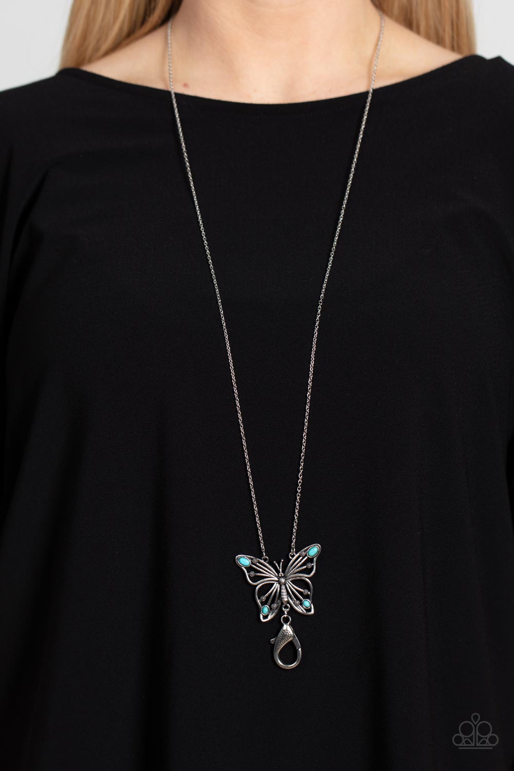 Paparazzi Accessories Badlands Butterfly - Blue *Lanyard Accented in oval turquoise stones, a decorative silver butterfly flutters at the bottom of a silver chain for a free-spirited finish. A lobster clasp hangs from the bottom of the design to allow a n