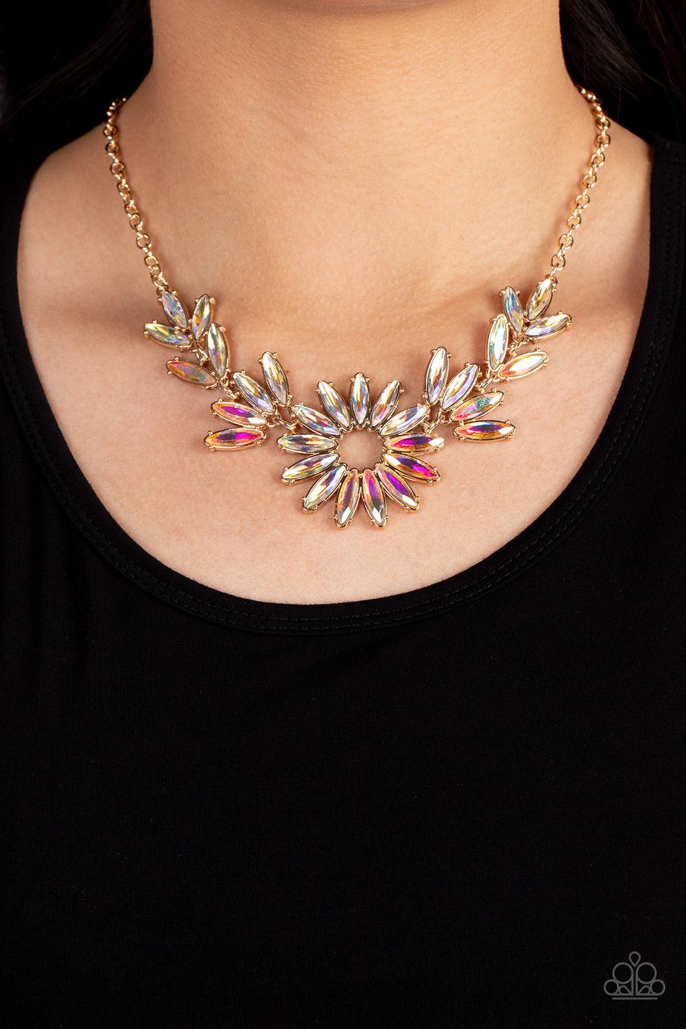 Paparazzi Accessories Celestial Cruise - Gold Featuring oblong marquise cuts, a collection of iridescent gems join into leafy gold frames below the collar. Radiating with the same iridescent intensity, even more stellar rhinestones fan out into a circular