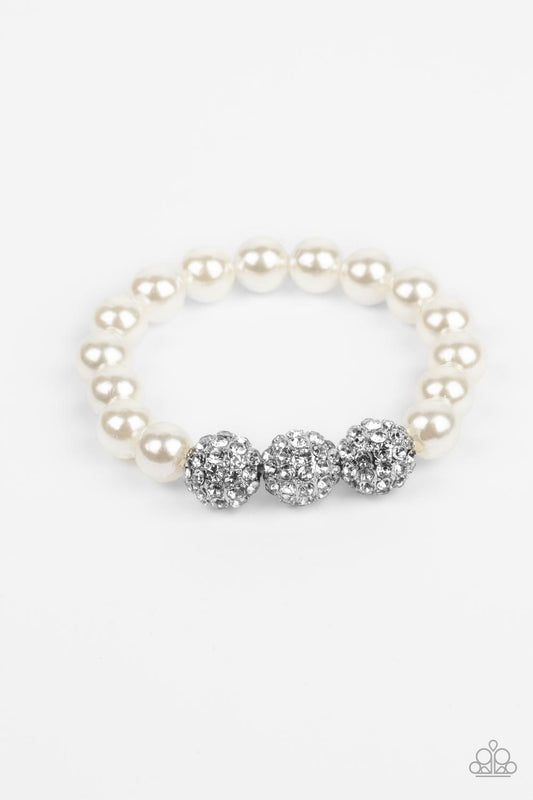 Paparazzi Accessories Breathtaking Ball - White A trio of silver beads encrusted in rhinestones is centered along a strand of classic white pearls. The beads are threaded along a stretchy band, wrapping around the wrist in a refined finish. Sold as one in