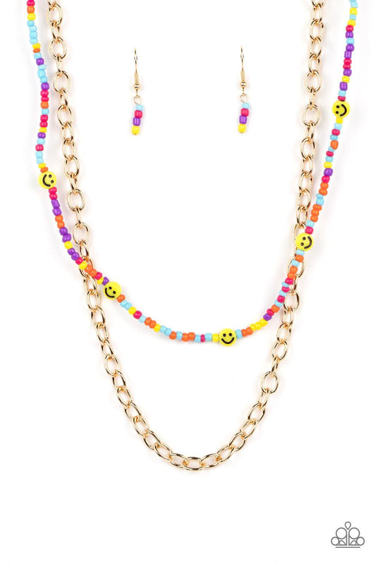 Paparazzi Accessories Happy Looks Good on You - Multi Layered together with a bold gold chain, dainty multicolored seed beads and yellow smiley face beads are threaded along an invisible wire below the collar, resulting in a colorfully retro design. Featu