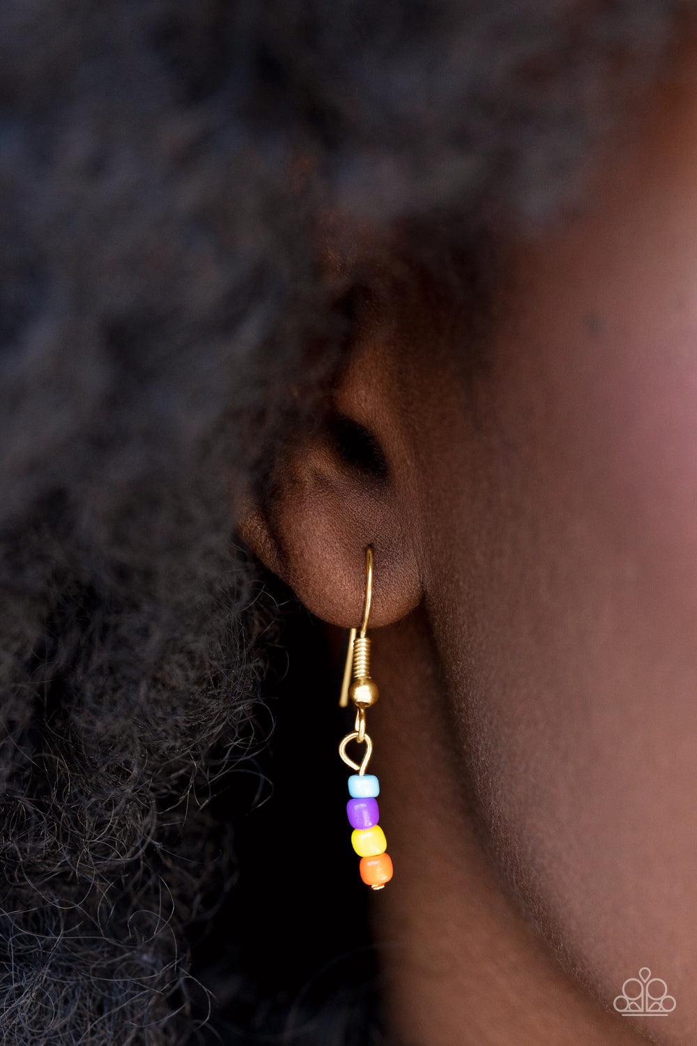 Paparazzi Accessories Happy Looks Good on You - Multi Layered together with a bold gold chain, dainty multicolored seed beads and yellow smiley face beads are threaded along an invisible wire below the collar, resulting in a colorfully retro design. Featu