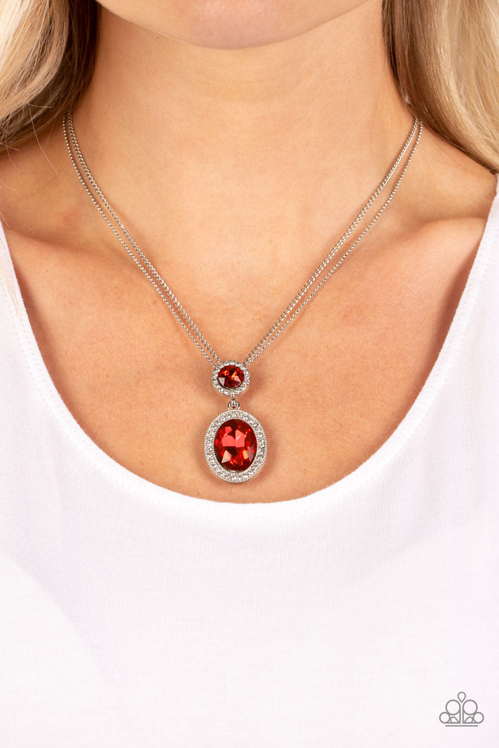 Paparazzi Accessories Castle Diamonds - Red A large oval red rhinestone is encased in a border of rhinestone-dusted silver, as it's suspended from a smaller version of the same design. The stacked pendant then slides along a pair of silver chains in a reg