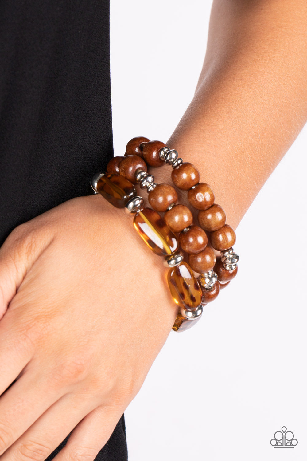 Paparazzi Accessories WILD-Mannered - Brown Featuring hints of cheetah-like patterns, glassy acrylic beads join dainty silver accents and oversized wooden beads along stretchy bands that stack across the wrist in a wildly layered finish. Sold as one set o