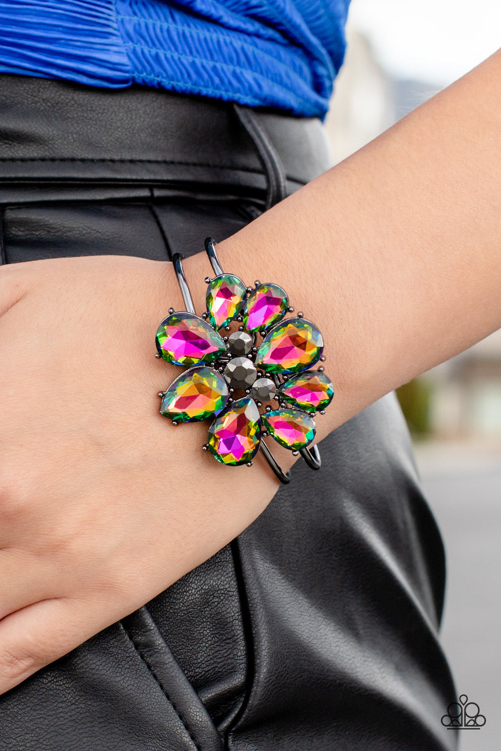 Paparazzi Accessories DAUNTLESS is More - Multi A dazzling collection of oil spill teardrop gems dramatically fan out around three round pieces of hematite, creating an explosion of sparkle. The exaggerated gems circle into a floral centerpiece that sits