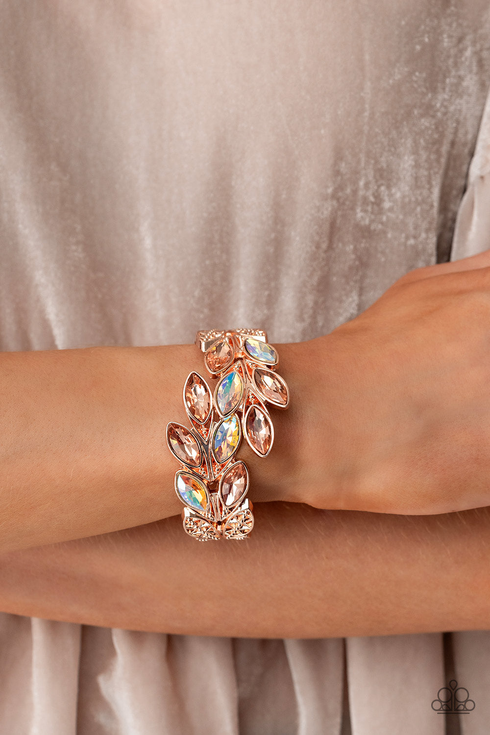 Paparazzi Accessories Luminous Laurels - Rose Gold Rose gold and peachy iridescent marquise-cut gems blossom from an array of rose gold marquise frames embossed in leafy filigree and tactile studs. Each frame interlocks around the wrist in a whimsical pat