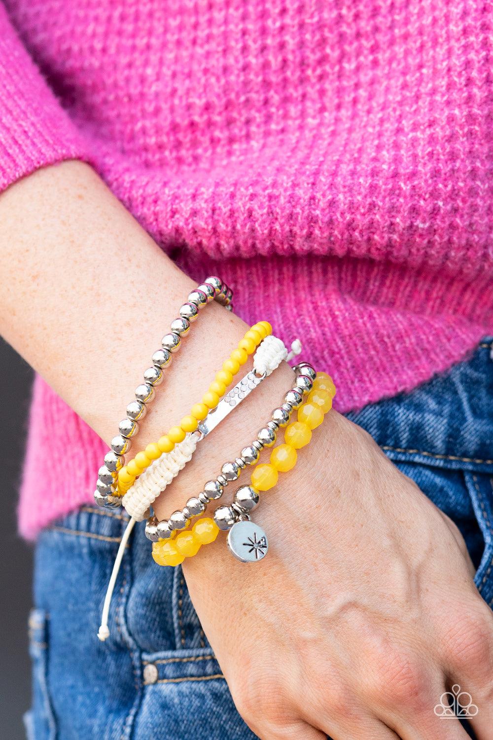 Paparazzi Accessories Offshore Outing - Yellow Strands of yellow beads in the vibrant Pantone® of Samoan Sun are threaded along stretchy elastic bands to create a stack of bracelets. The varying opacities of each yellow bead adds depth to the design, as a