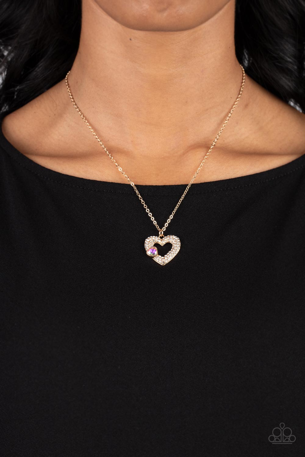 Paparazzi Accessories Bedazzled Bliss - Multi A luxurious airy gold heart lush with glassy white rhinestones swings from a classic gold chain. A faceted heart gem brushed in an iridescent shimmer graces one side of the larger bedazzled heart for a romanti