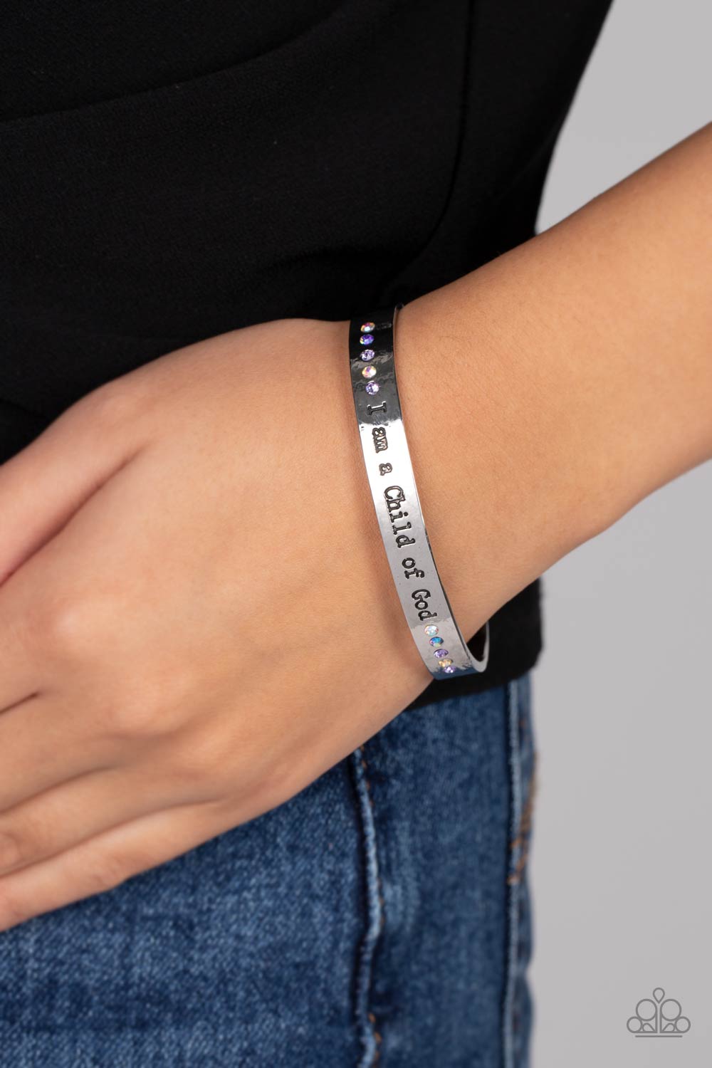 Paparazzi Accessories Divine Display - Multi A shiny silver cuff stamped with the phrase "I am a Child of God" encircles the wrist. Dainty sapphire, violet and iridescent rhinestones shimmer at the borders of the phrase for a whimsical finish. Due to its