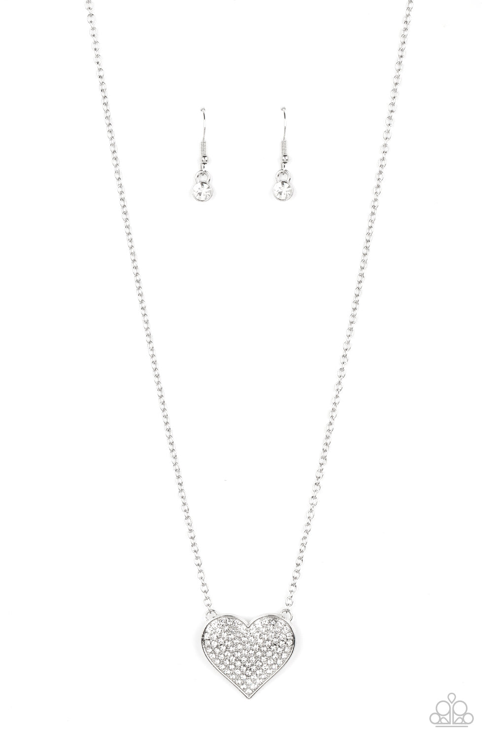 Paparazzi Accessories Spellbinding Sweetheart - White A heart-shaped pendant in a silver finish is anchored between two strands of delicate chain in the same reflective finish. The interior of the heart is filled with glittery white rhinestones, inviting