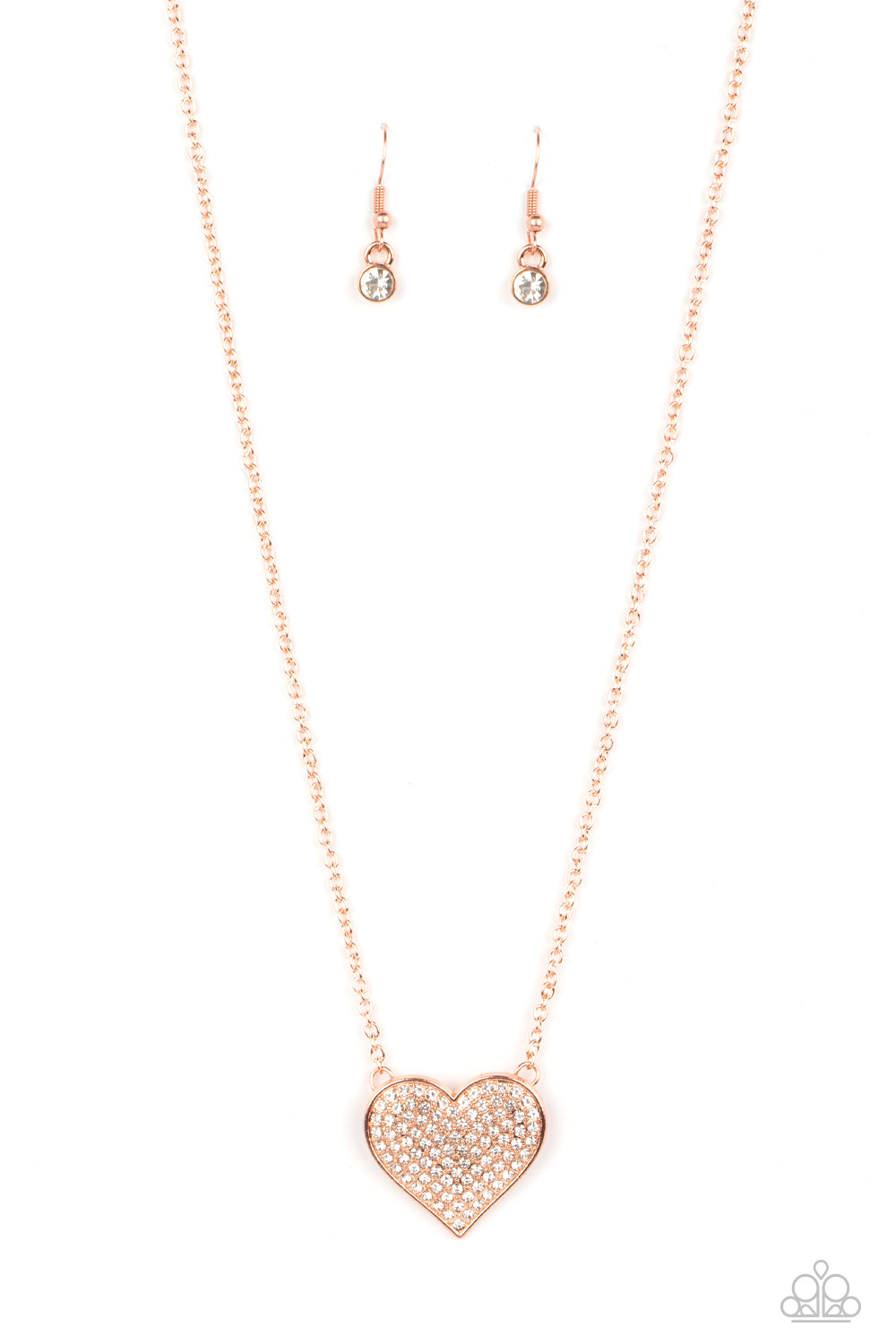 Paparazzi Accessories Spellbinding Sweetheart - Copper A heart-shaped pendant in a shiny copper finish is anchored between two strands of delicate chain in the same reflective finish. The interior of the heart is filled with glittery white rhinestones, in