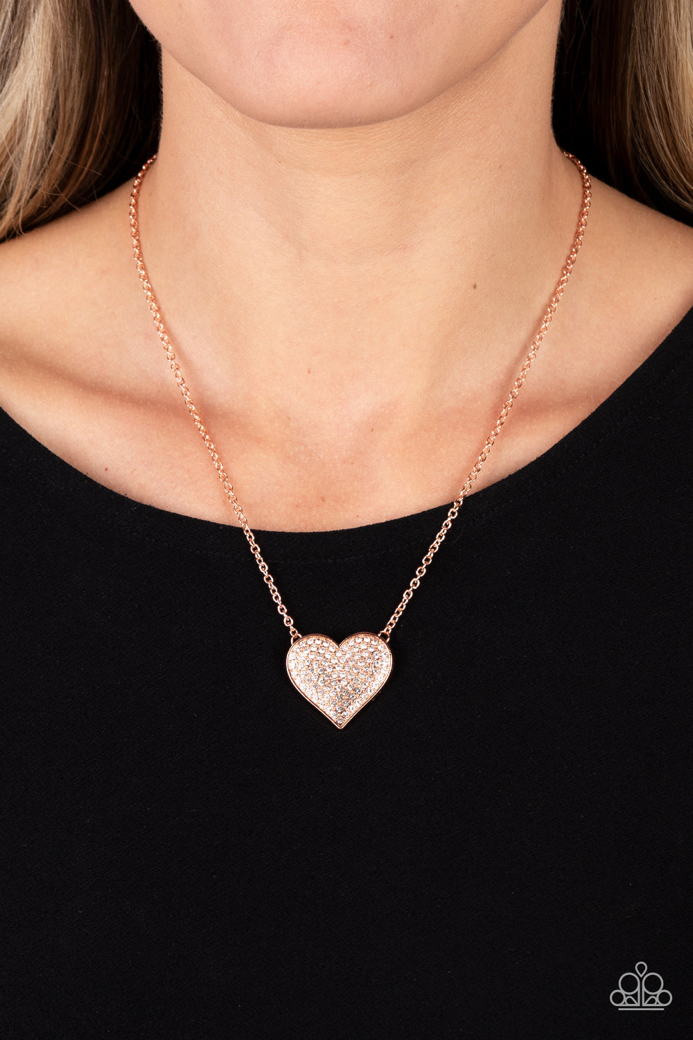 Paparazzi Accessories Spellbinding Sweetheart - Copper A heart-shaped pendant in a shiny copper finish is anchored between two strands of delicate chain in the same reflective finish. The interior of the heart is filled with glittery white rhinestones, in