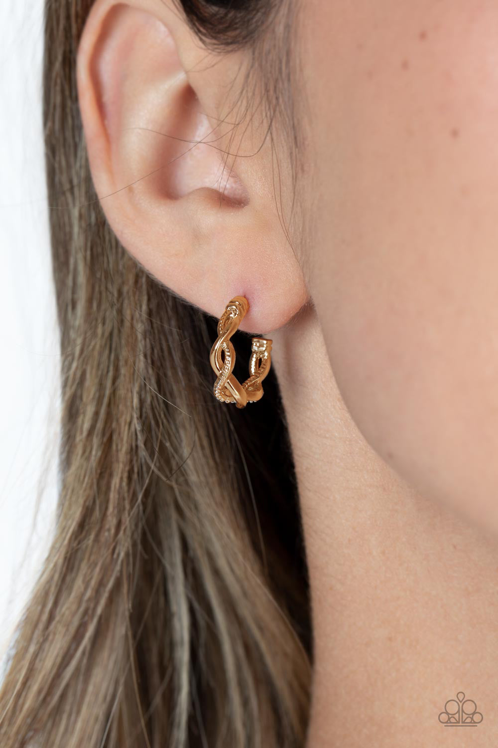 Paparazzi Accessories Infinite Incandescence - Gold Shiny gold and studded gold curve around one another in an infinity-like pattern. The contrasting sheen of the gold curves around the ear for an incandescent hoop. Earring attaches to a standard post fit