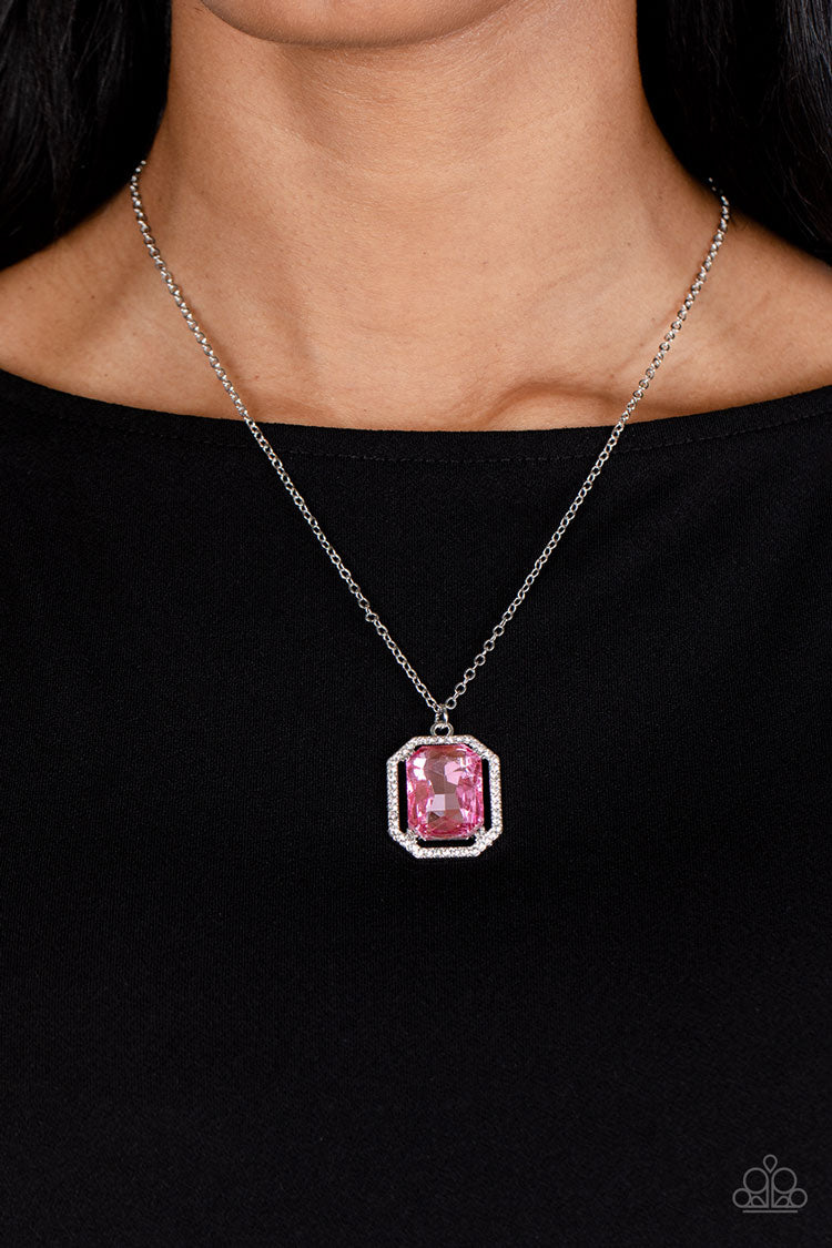 Paparazzi Accessories Galloping Gala - Pink A dramatically oversized, emerald-cut pink gem shimmers as it swings from the bottom of a long silver chain. Dainty white rhinestones create an airy frame that wrap around the reflective centerpiece, scattering