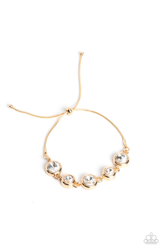 Paparazzi Accessories Classically Cultivated - Gold Varying sizes of classic, round, brilliant-cut white rhinestones set in thick, circular, gold frames link together around the wrist with glamorous glimmer. The rhinestones attach to a dainty strand of go