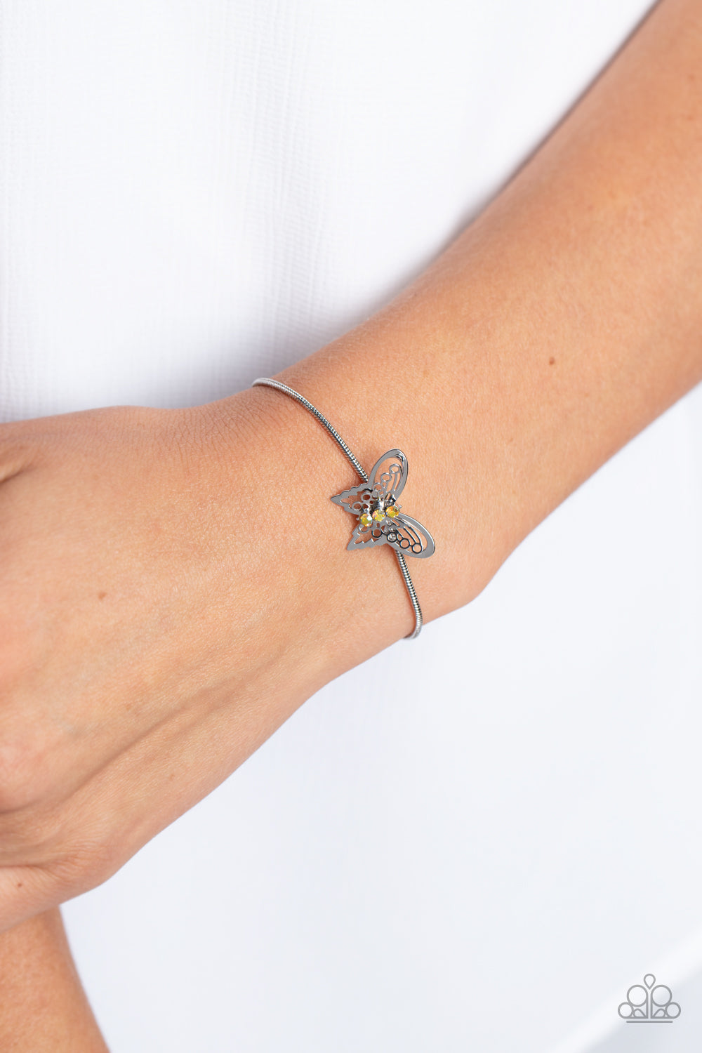 Paparazzi Accessories Wings of Wonder - Yellow A deceptively simple silver butterfly charm glides along a silver snake chain for a whimsical flair along the wrist. Dainty, yellow rhinestones, brushed in a UV shimmer, encrust along the butterfly's body, cr