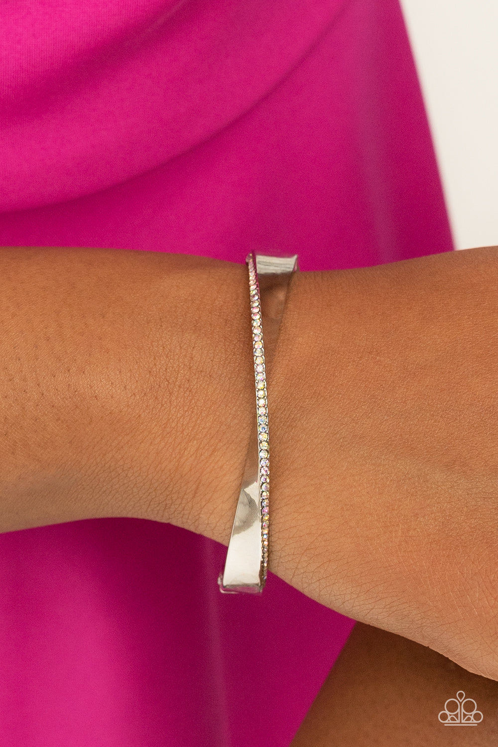 Paparazzi Accessories Artistically Adorned - Multi An oversized, warped, shiny silver bracelet wraps around the wrist in an artistic manner. A dainty row of iridescent rhinestones encrusts along the curves for an understated, elegant dazzle. Features a hi