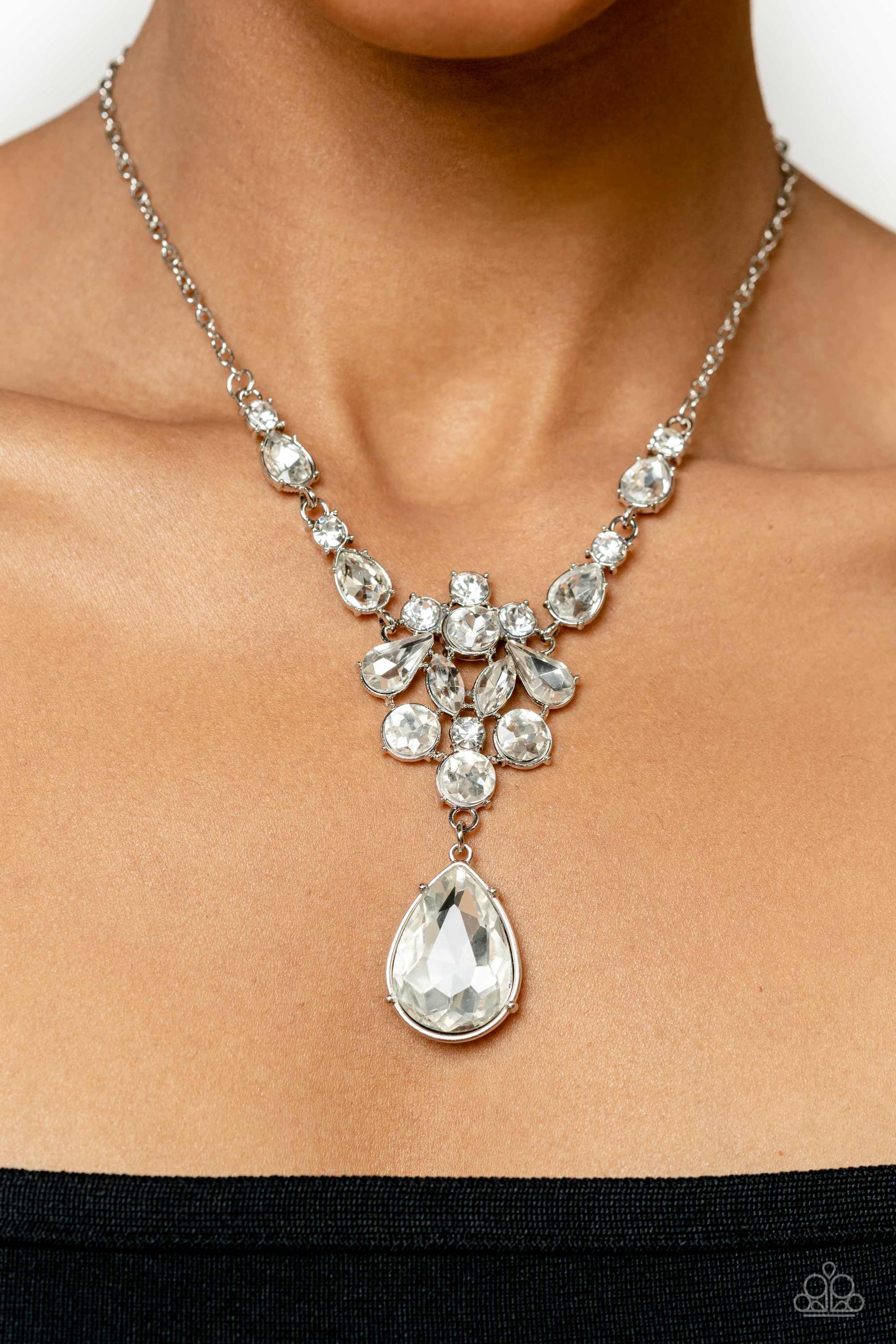 Paparazzi Accessories TWINKLE of an Eye - White Adorned with a dainty silver chain, a twinkling collection of white, reflective teardrops, rhinestones and marquise-cut gems glitter down the chest. Hanging at the bottom of the glittery collection, an overs
