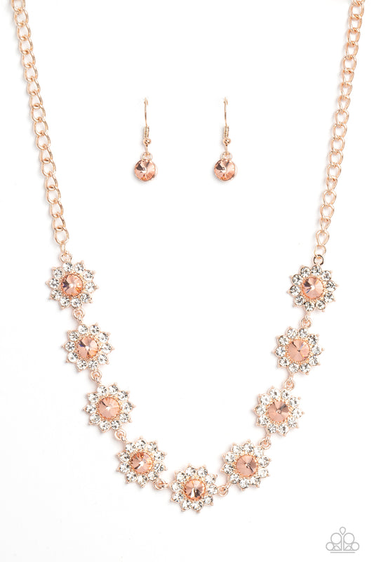 Paparazzi Accessories Blooming Brilliance - Rose Gold Shiny white rhinestone petals bloom from a shimmery peachy center, creating a whimsical floral arrangement of rose gold below the collar. Features an adjustable clasp closure. Sold as one individual ne