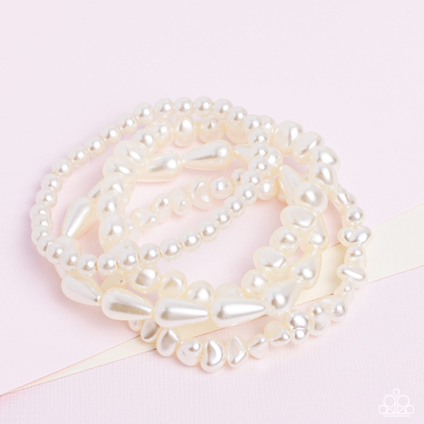 Paparazzi Accessories Gossip PEARL - White An abstract collection of geometric white pearls coalesces around the wrist in four layers on elastic stretchy bands for a fashionably, refined stack. Sold as one individual bracelet. Jewelry